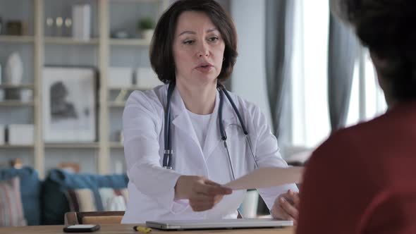 Old Lady Doctor Giving Medical Report To Patient in Clinic