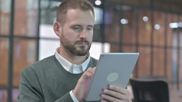 Portrait Shoot of Ambitious Man Scrolling on Tablet