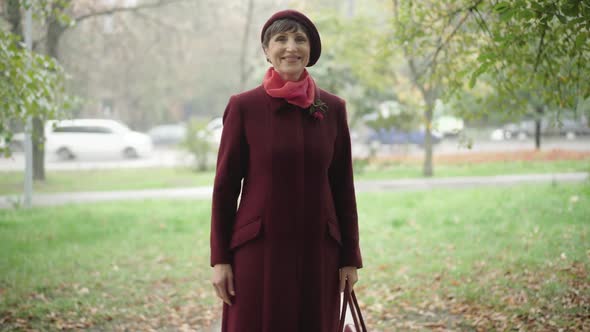 Portrait of Gorgeous Senior Woman Posing on Autumn Day Outdoors. Happy Beautiful Caucasian Female