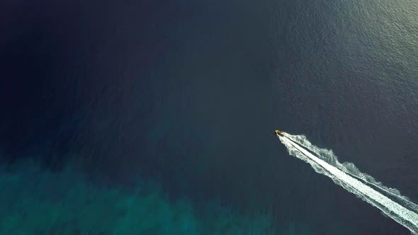 Aerial view of a jet ski passing through the Caribbean Sea leaving the wake of water behind, Westpun