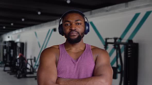 African American Man with Headphones Looking at the Camera in the Gym