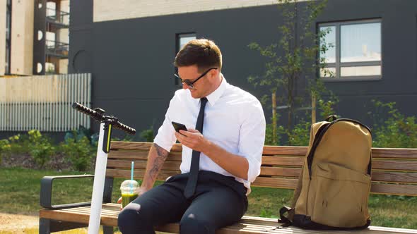 Businessman with Smartphone Drinking Smoothie