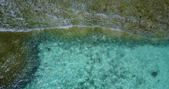 Wide aerial clean view of a paradise sunny white sand beach and aqua blue water background