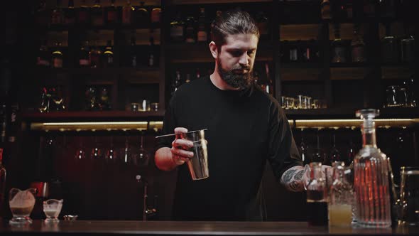 Bartender Pours Cocktail From Shaker Into Chilled Wineglass