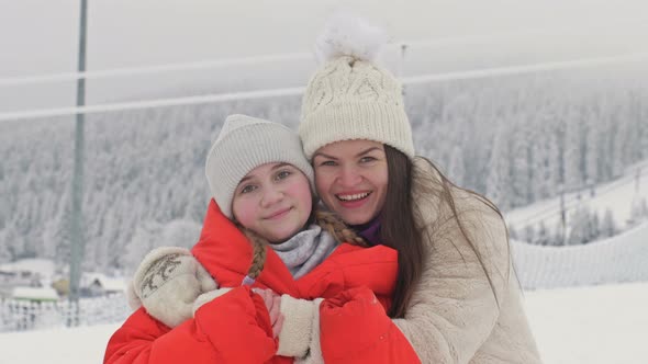 Family Portrait of a Young Woman with Her Teenage Daughter on the Background of a Winter Landscape