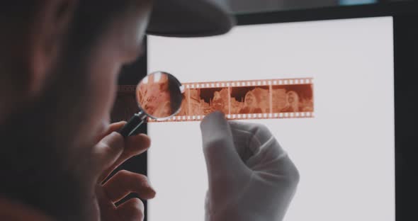 A young man examines filmstrip