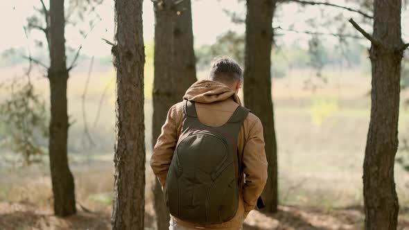 Casual Style Man in Autumn Woods with Backpack