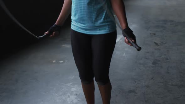 African american woman skipping the rope in an empty urban building