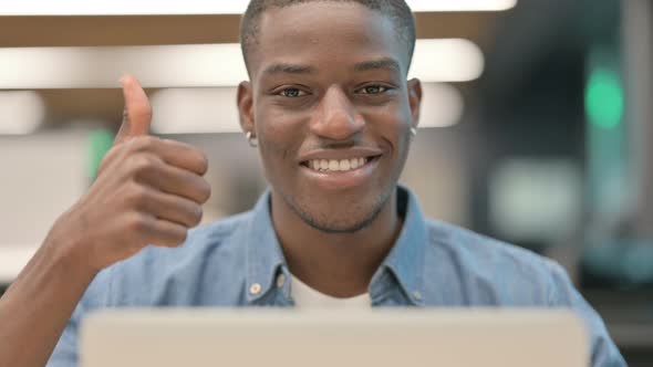 African American Man Showing Thumbs Up at Work