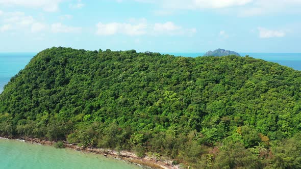 Uninhabited green Thailand island with exotic vegetation and preserved nature. turquoise sea washing