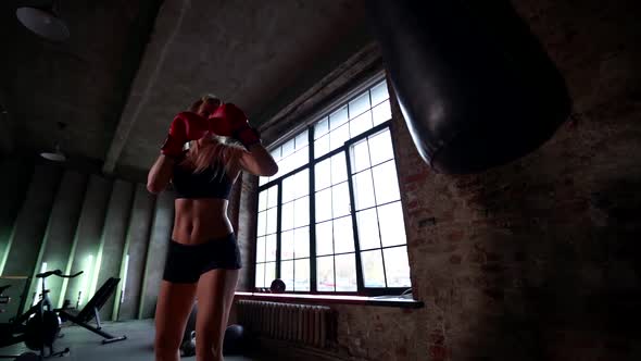 Sportswoman Is Boxing in Gym, Training Alone, Striking By Punching Bag, Sport Activities