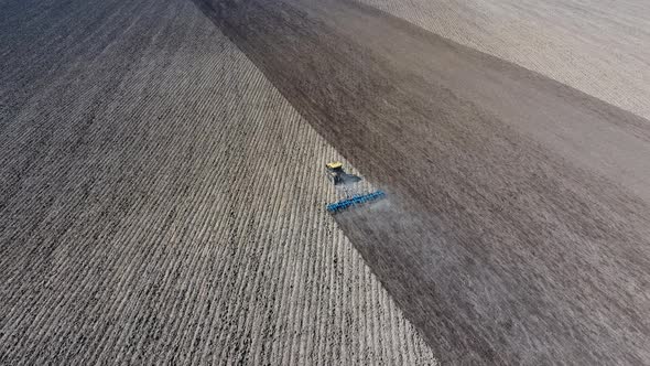 The Tractor Harrows the Soil on The Field for Sowing