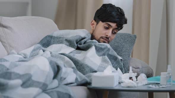 Indian Bearded Sad Exhausted Man Lying on Home Couch Ill Covered Blanket Suffering From Fever