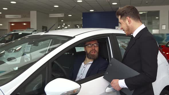 Sales Manager Shows Customer Something on Clipboard