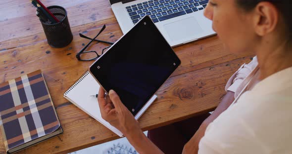 Caucasian woman using digital tablet, working from home