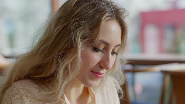 Headshot Portrait of Young Blond Caucasian Woman Enjoying Tasty Food in Restaurant