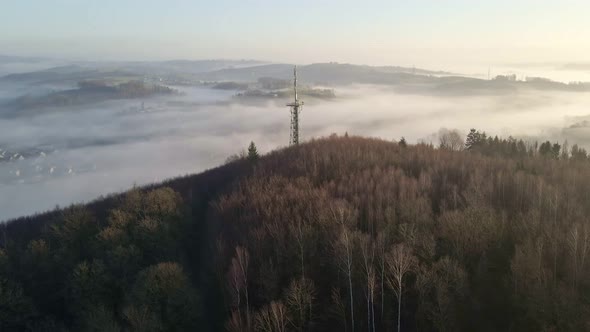 Observation tower with transmission mast at sunrise sitting on the edge of a steep hill in Morsbach,