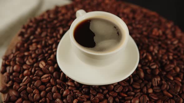 Cup of Coffee and Saucer on Coffee Beans