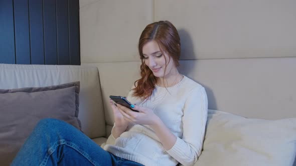 Happy Relaxed Young Woman Holding Smart Phone Looking At Cellphone Screen Chatting In Dating App