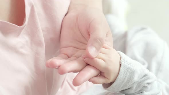 Newborn Baby Hand Holding Mother Mom Touching Baby Tiny Hand to Make Him Feeling Her Love Warm and