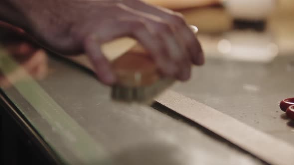 A Man Polishes the Leather Belt Using a Brush