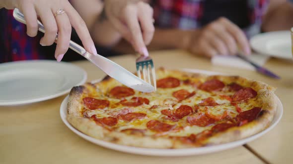 Woman Hands are Cutting Hot Pizza