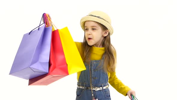 Little Girl Holding Her Purchases and Surprised Them. White Background. Slow Motion