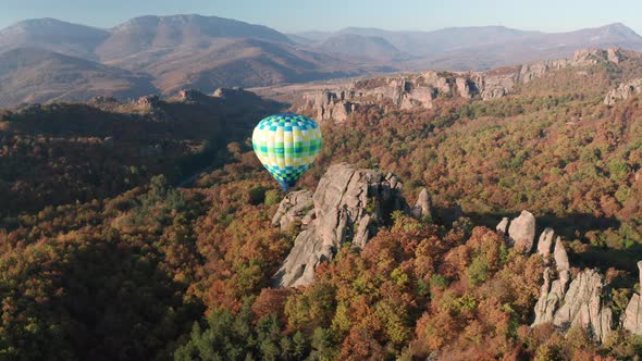 Hot air balloon flying over picturesque rock formation