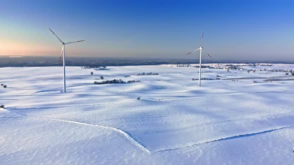 Alternative energy in winter, Poland. Wind turbine on snowy field.
