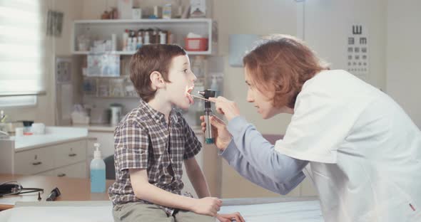 Female doctor examining a young boy in a clinic