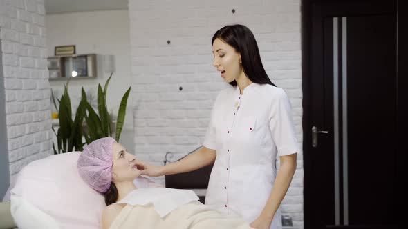 Attentive cosmetologist advises the client before the procedure in the beauty salon.