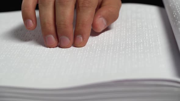 Male Hands Reading a Braille Book. Close Up