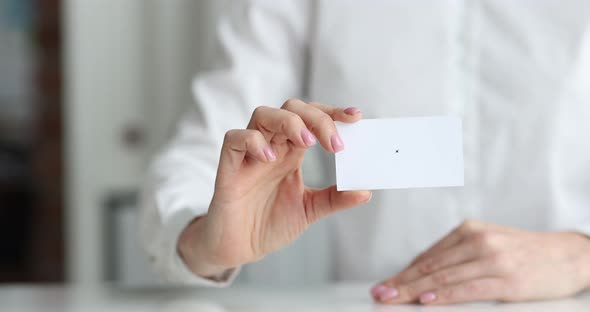 Woman Sitting at Table and Holding Blank Business Card in Her Hands Closeup  Movie