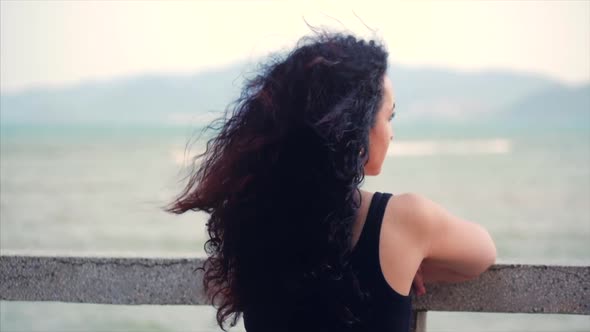 Wonderful Caucasian Woman Looking at Ocean View at Sunset. Young Beautiful Girl Enjoying Nature