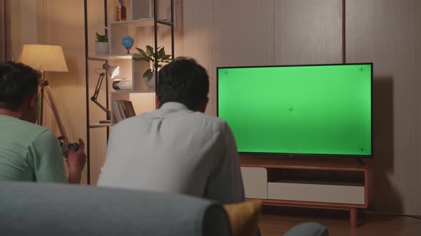 Young Friends With Joystick Game Play Video Game On Green Screen Tv