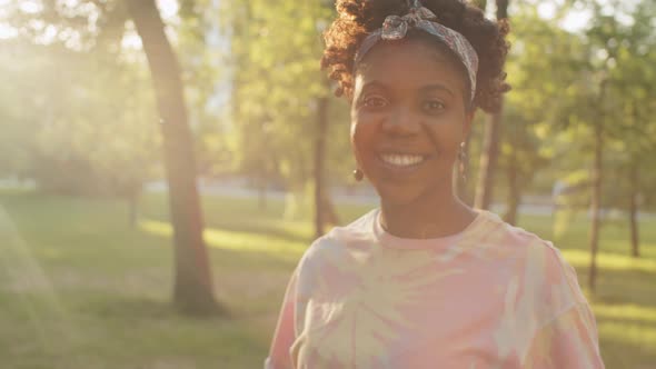 Portrait of Joyous Afro-American Woman Outdoors on Sunny Day