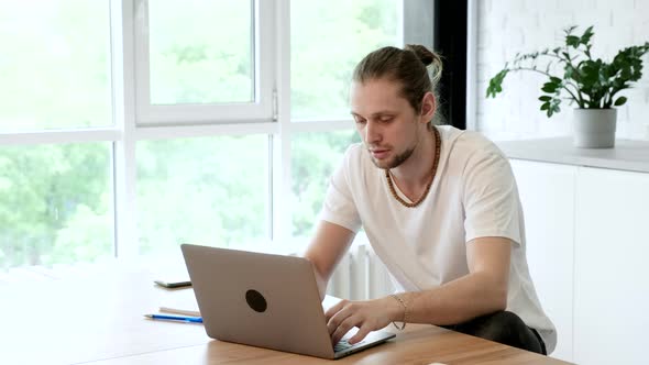 Side view handsome young businessman in eyewear working with computer remotely