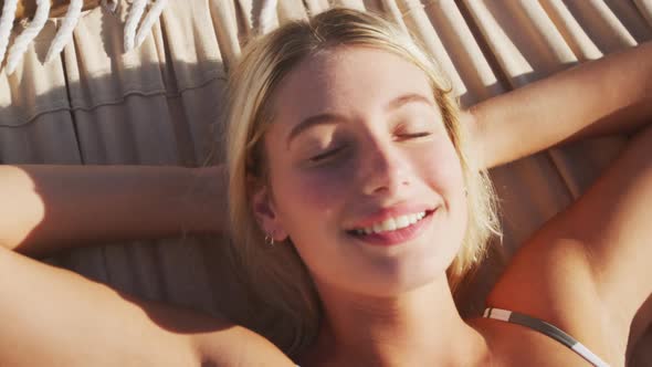 Caucasian woman lying on a hammock on the beach