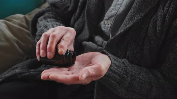 Elderly Senior Puts White Pills on Palm Takes Pills and Drinks with a Glass of Water