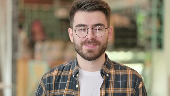 Portrait of Cheerful Young Man Waving Hello