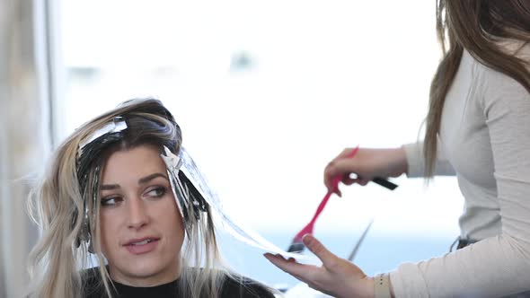 Woman getting her roots touched up at salon