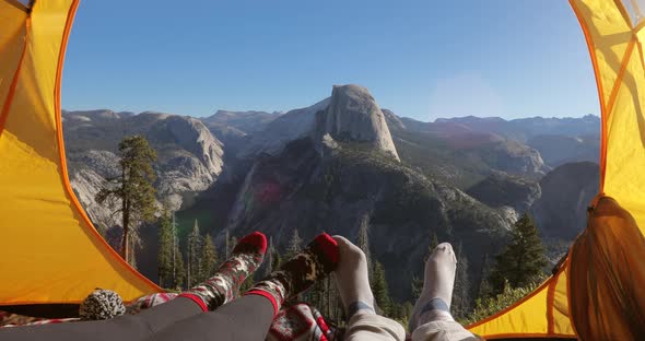 Two People Rest in a Tent Overlooking the Yosemite Valley.They Point Their Fingers at Half Dome Rock