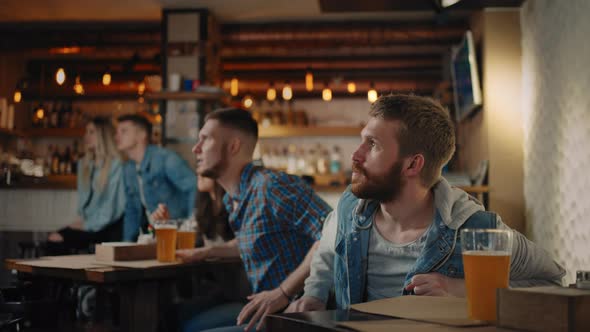 A Group of People in a Pub Cheers for Their National Team at the World Cup