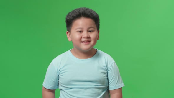 Smiling Asian Little Boy Positively Shaking His Head At The Camera In The Green Screen Studio