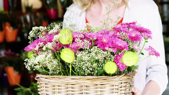 Mid-section of female florist holding bunch of flower in flower shop