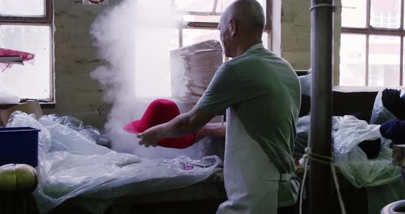 Mixed race man working at a hat factory