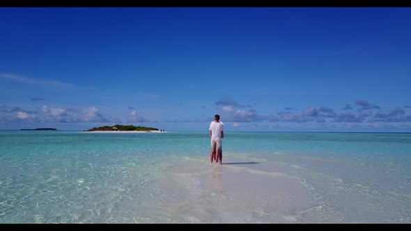 Two lovers suntan on relaxing tourist beach journey by shallow sea and white sand background of the 