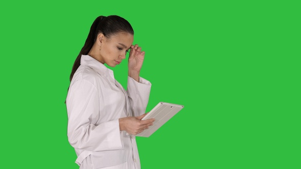 Woman doctor using tablet pc and walking on a Green Screen