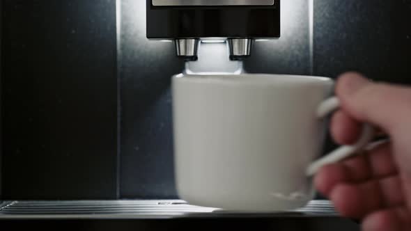 Person Placing a Cup Onto an Espresso Machine