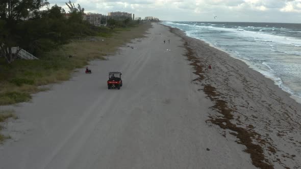 Lifeguard driving golf cart along the beach on patrol